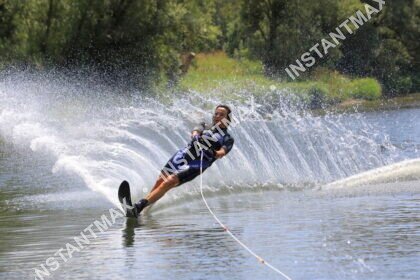 Skieur nautique en plein virage projetant un spectaculaire rideau d’eau