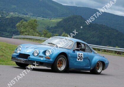 Alpine A110 bleue numéro 56 en pleine course sur une route de montagne