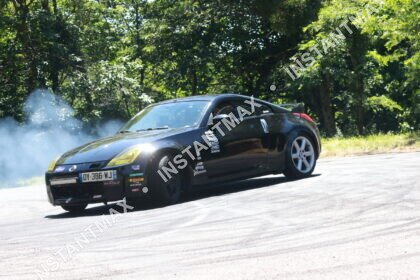 Nissan 350Z noire réalisant un drift avec fumée des pneus sur route