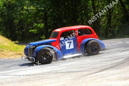 Legend Car rouge et bleue numéro 7 en pleine glisse dans un virage