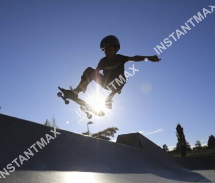 Skateur en plein saut à contre-jour avec le soleil sous son skateboard